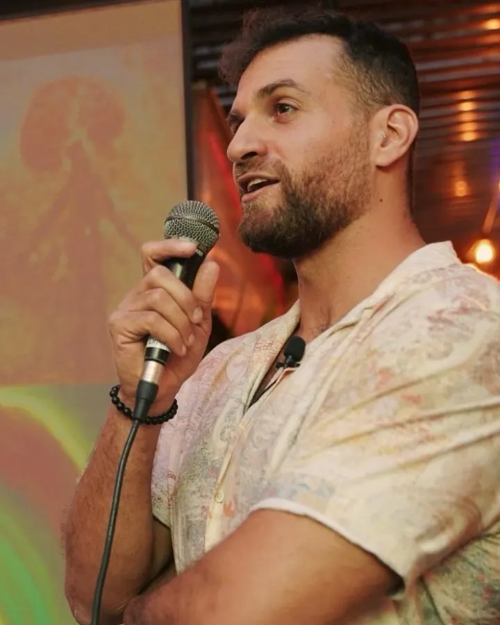 אמיר הררי מרצה עם מיקרופון ביד
